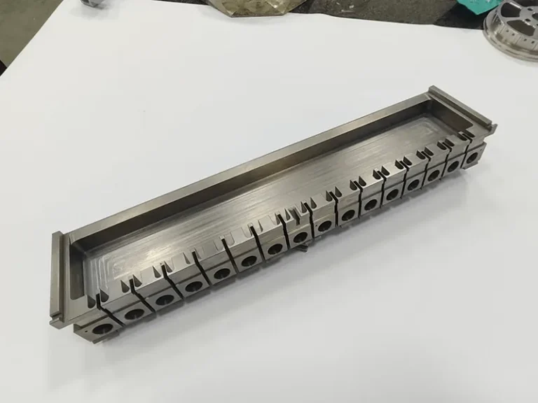 Long die holder with a ganged row of 17 wire-cut inserts, view 2