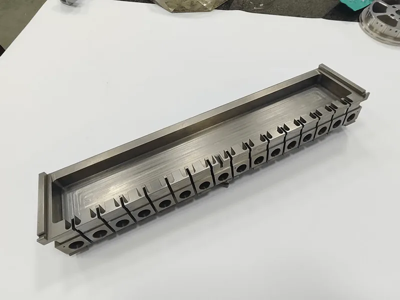 Long die holder with a ganged row of 17 wire-cut inserts, view 2