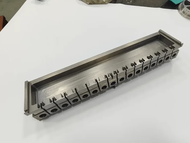 Long die holder with a ganged row of 17 wire-cut inserts, view 3