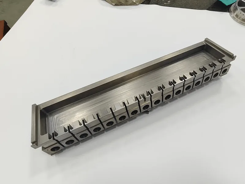 Long die holder with a ganged row of 17 wire-cut inserts, view 3