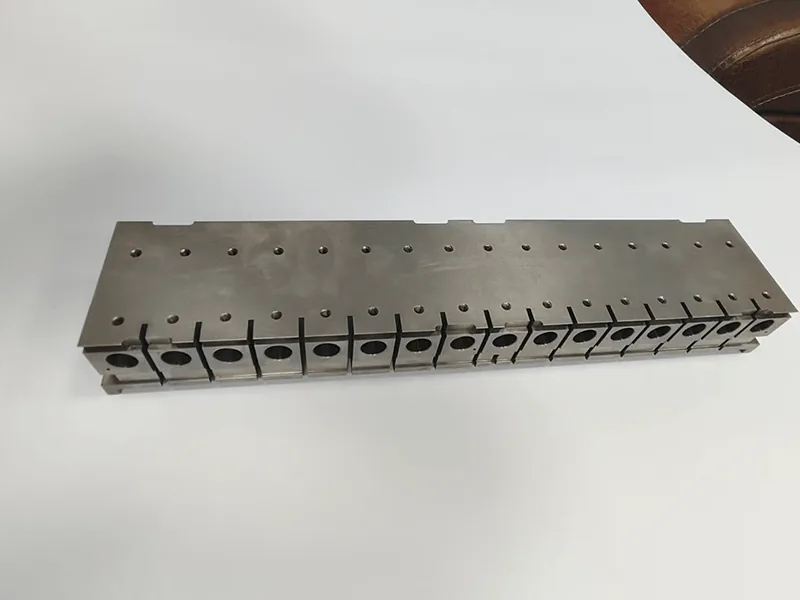 Long die holder with a ganged row of 17 wire-cut inserts, view 4