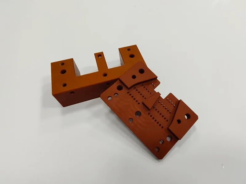 Machined orange laminate insulator bracket set, two parts, top view
