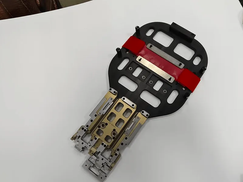 Robot end-of-arm gripper: pocketed base plate, red urethane pads, anodized manifold, stainless fingers