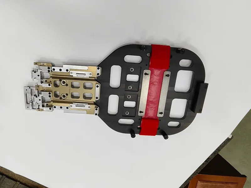Robot end-of-arm gripper: pocketed base plate, red urethane pads, anodized manifold, stainless fingers, view 2