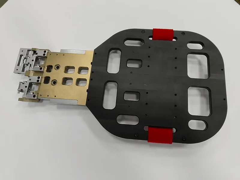 Robot end-of-arm gripper: pocketed base plate, red urethane pads, anodized manifold, stainless fingers, view 4