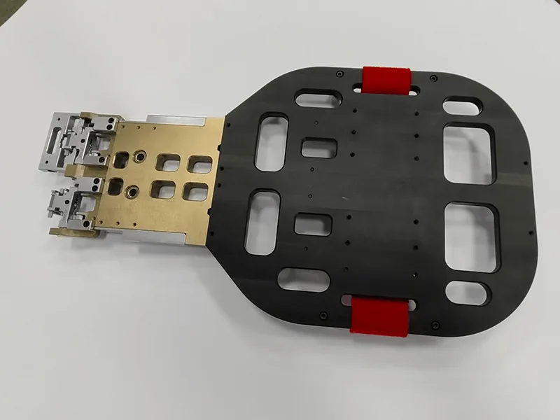 Robot end-of-arm gripper: pocketed base plate, red urethane pads, anodized manifold, stainless fingers, view 5